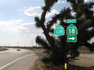 Westbound California 138 meets California 18 (Pearblossom Highway). Turn right to follow California 18 (Pearblossom Highway) west to Victorville and Lucerne Valley, or continue ahead on California 138/Pearblossom Highway west to Pearblossom, Littlerock, and Lancaster. This intersection marks the western terminus of California 18.