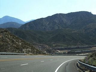 Descending from the Cajon Pass, the Interstate 15 freeway corridor and railroads come into view as westbound California 138 quickly loses elevation.