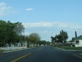 Residences and houses line both sides of California 33-140. The state route follows South Avenue, which changes into 6th Avenue after passing 6th Street.