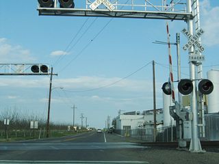 After leaving California 33/Fourth Street, eastbound California 140 crosses a railroad.