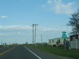 A California 140 east reassurance shield is posted shortly thereafter; the state highway starts to leave the city of Gustine.