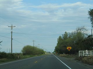 Eastbound California 140 approaches California 165 (Lander Avenue) near the town of Stevinson. Two stop ahead signs warn of the pending intersection.