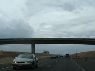 California 149 passes under a one-lane bridge that connects to Openshaw Road, the frontage road that is the original alignment of California 149. (This configuration, which shows the southbound lanes still under construction, has since been upgraded to four lanes on two separate carriageways.)