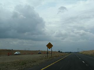 Under the new configuration, four-lane California 149 has an expressway segment with only one at-grade intersection (hence the "end freeway 1/2 MILE" sign posted here). The 500kV Pacific Gas & Electric power lines, which span most of the state of California, will pass over California 149 ahead near the intersection with Openshaw Road and Shippee Road (which is approximately one-half mile ahead).