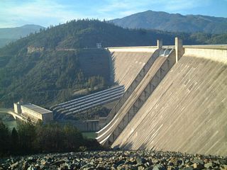Shasta Dam holds back the Sacramento River to form Shasta Lake, a source of water for agricultural irrigation and urban centers. The water is also used to produce hydroelectricity as it cascades through power-producing turbines back into the river.