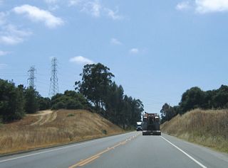 Overhead, a set of 138 kV, 230 kV, and 500 kV power lines cross California 156. These lines emanate from the Moss Landing Power Generating Station, and the 500 kV line travels northwest to the Los Banos Substation located south of the California 33-152 interchange near Santa Nella and west of Interstate 5.