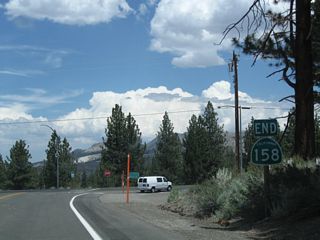 An end California 158 shield assembly stands at the intersection with U.S. 395.