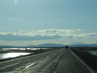 After the High Rim road cut, California 161 west enters Lower Klamath National Wildlife Refuge, which was established in 1908 and is the first refuge devoted to waterfowl. Both sides of California 161 have wetlands and ponds that form part of the habitat for migratory birds. With a particularly wet winter in 2004-5, the wetlands are especially full.