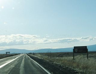 Large flocks of birds pass over California 161 as the highway passes the Lower Klamath National Wildlife Refuge sign.
