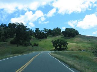 East of Dos Rios, California 162 pulls away from the Eel River and climbs over a pass over the Poonkinny Ridge, with Round Mountain visible to the east.