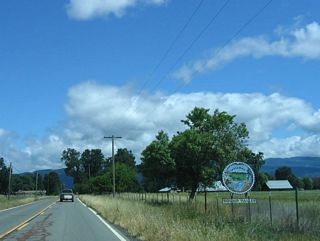 A circular welcome sign for Round Valley is posted alongside California 162.