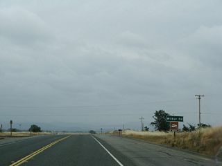 Eastbound California 162 approaches the intersection with Wilbur Road, which travels north to Oroville Junction. The road south reaches a dead end near a branch of the Thermalito Afterbay.