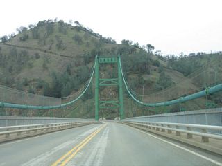 This Bidwell Bar Bridge, which rises to an elevation of 627 feet above the streambed, replaced the original Bidwell Bar Bridge, which crossed the river prior to the construction of the dam and inundation of the site of the original bridge.