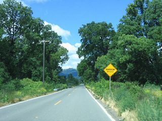 A narrow bridge sign is posted as westbound California 162 approaches Mina Road.