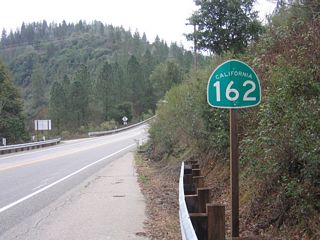 California 162 begins westbound along Oroville-Quincy Highway at the intersection with Foreman Creek Road in Lake Oroville State Recreation Area. The state route helps carry through traffic through the bridges necessitated by the creation of Lake Oroville and also allows access to several recreation area sites along the way. California 162 will mostly travel south until curving west toward the city of Oroville. This is the first westbound shield for California 162.