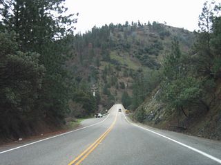California 162 will cross two major bridges to follow the eastern edge of Lake Oroville. The first bridge is the Canyon Creek Bridge, which is visible at the bottom of this grade. The bridge was built in 1967 and allows California 162 to pass above this branch of Lake Oroville. A second bridge, the Bidwell Bar Bridge (suspension bridge) is a bit further south of here.