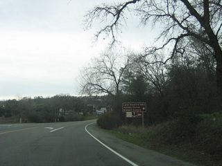 Westbound California 162 approaches the turnoff to Kelly Ridge Road. Turn right at the next intersection to the Lake Oroville State Recreation Area visitors center.