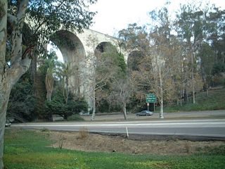 The Cabrillo Freeway threads through the canyon below the Cabrillo Bridge, and a culvert carries the water that used to flow naturally through the canyon.