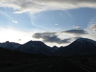 The towering peaks of the Sierra Nevada dominate the view as the highway continues to gain elevation.