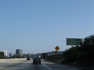 Traffic from U.S. 101 merges onto the Hollywood Freeway from the right. An identical mileage sign is posted on the U.S. 101 connecting ramp.