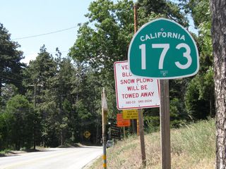 This is the first California 173 west reassurance shield after the intersection with California 18 (Rim of the World Highway). From here, California 173 will travel north to Lake Arrowhead, pass alongside the eastern edge of the lake, then turn north and northwest toward the dirt road section.