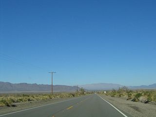 Joshua Tree National Park, which includes the Coxcomb Mountains that are seen in the distance, encompasses much of the distant mountain skyline. While California 177 skirts the eastern edge of the national park at certain locations, it stays outside of the park. Use California 177 north to California 62 west to access Joshua Tree National Park.