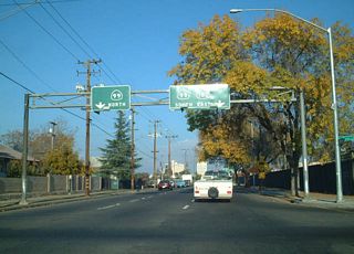 A sign bridge along Tuolumne Street east at B Street references the split diamond interchange with SR 99. Theses overheads were amended to remove shields for SR 180.