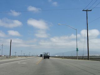 This reassurance shield is posted after the Cooper Road intersection. Cooper Road travels southwest to Blanco Road. A right turn from Cooper Road onto Blanco Road west leads to the city of Marina, California State University at Monterey Bay, Marina Municipal Airport, and California 1 (Cabrillo Highway).