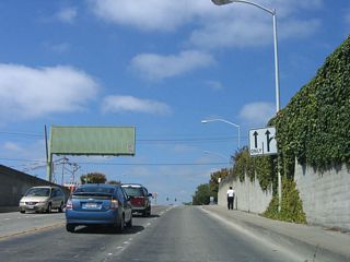 Northbound U.S. 101 Business and southbound California 183 approach the intersection with Lake Street. No left turn is permitted. The overhead guide sign in the other direction shows the split of U.S. 101 Business and California 183 at the Market Street intersection.