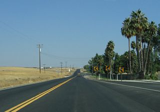 Development lines the southeast side of the highway (including Hillcrest Memorial Park), while the hills to the northwest are not developed.