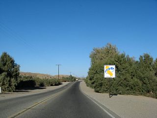 State law requires that front seat passengers wear a seat belt. Signs like this on northbound California 186 were posted in 2004 to advise motorists of the law.