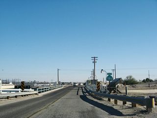 A California 186 south reassurance shield is posted as Algodones Road crosses over the All American Canal near the Rockwood check diversion gate. Despite the fact that the Colorado River lies very close to the canal, the All American Canal does not begin (diverge from the river) at this point. While there is a connection between the canal and the river via the Rockwood gate, the All-American Canal initially diverges from the river at Laguna Dam off Imperial County S-24.