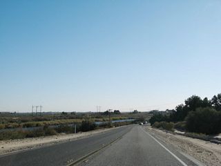 Aiming a bit southeast, a diversion canal of the Colorado River comes into view shortly after the All American Canal crossing. The power lines are located on a strip of land located between the diversion canal and the river. The highway will turn southwest for its final distance to the small town of Andrade and the border crossing with Mexico.