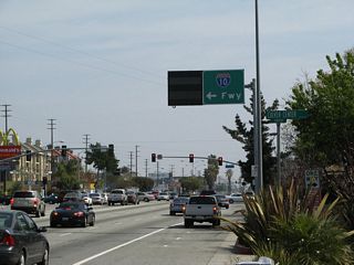 Eastbound California 187 (Venice Boulevard) approaches Overland Avenue. Turn left on Overland Avenue to connect to Interstate 10 (or continue east on Venice Boulevard).