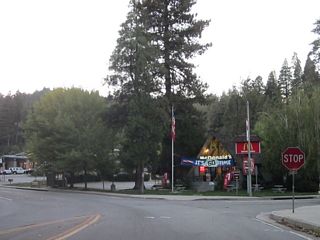 Westbound California 189 intersects N Bay Road at this stop sign in Blue Jay. N Bay Road provides access to the western and northern shores of Lake Arrowhead as well as access back to California 173. Food and shopping are available along the short commercial strip in Blue Jay.