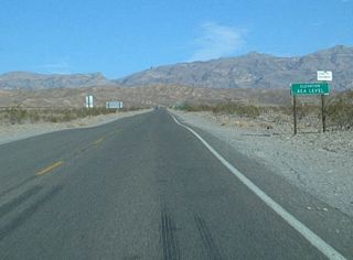 An elevation Sea Level sign is posted shortly thereafter along eastbound California 190 in Death Valley National Park.