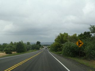 Soon thereafter, California 191 returns to its original alignment and proceeds north on a rural segment of two-lane state route. Storm clouds gathered on the horizon on this late spring day as California 191 passes through a pastoral, rural setting.