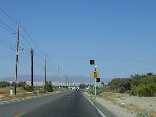 Power lines pass overhead as eastbound former California 195 (66th Avenue) approaches its signalized intersection with the California 86 expressway just west of Mecca.