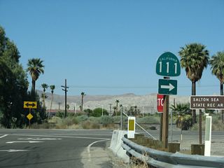 California 195 ends at this stop sign intersection with California 111 in Mecca. Turn right for the continuation of California 111 south to Niland and Calipatria. Turn left to the Fourth Street traffic signal, which connects to the unincorporated community of Mecca and the connection to Historic U.S. 60-70 (Box Canyon Road) east to Chiriaco Summit (old California 195).