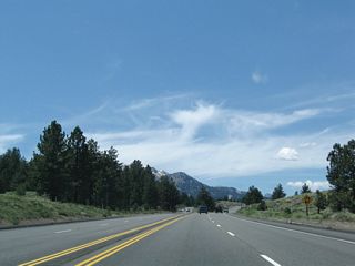 California 203 widens to expressway standards as a median barriers separates the two directions of highway travel.