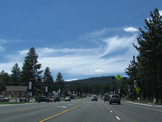 Westbound California 203 (Main Street) next meets Laurel Mountain Road at this intersection, which has a signed pedestrian crossing. Most services line the south side of Main Street via a frontage road that parallels California 203.