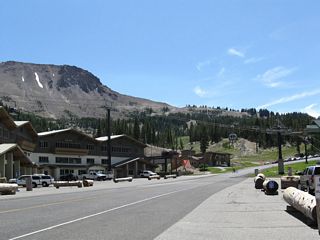 Passing through the Mammoth Mountain resort parking lot, a gondola line passes over the state route. Park here to ride the gondola or to see Devils Postpile and Reds Meadow. California 203 ends about one mile east of here at the Mono-Madera County Line at Minaret Summit. Beyond Minaret Summit (el. 9,174 feet), traffic is metered to allow only campers and shuttle buses. All day-use visitors between 7:00 a.m. and 7:00 p.m. are required to use the shuttle. The shuttle has not always been in place; it was first activated in 1980.
