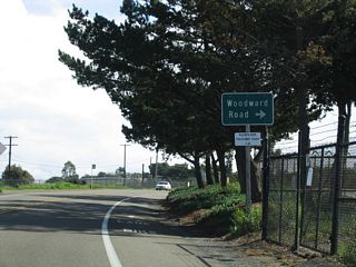 Cabrillo Memorial Drive runs south through Fort Rosecrans Military Reservation with two lanes to Woodward Road.
