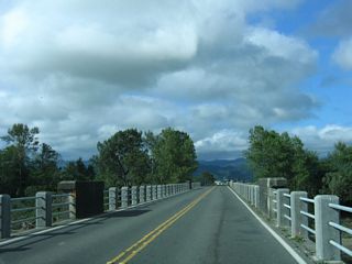 The floods of 1964, which destroyed multiple bridges upriver along the Eel River, did not destroy the Fernbridge. Debris from upriver could pass between the wide arches. About seven months before this photo was taken (December 2005), the Fernbridge was threatened by floodwaters due to the heavy rains of that year, but the bridge survived unscathed.