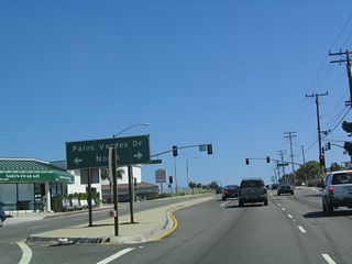 Southbound California 213 (Western Avenue) approaches Palos Verdes Drive North. Palos Verdes Drive is divided into four geographic parts, creating a Palos Verdes Drive North, East, South, and West. Together, they form a rough loop around the city of Rancho Palos Verdes, with some spurs emanating from the loop into adjoining cities.