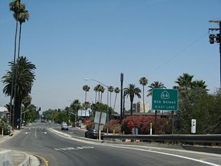 This view shows the connection from Interstate 215 south to California 66 west. Traffic briefly follows Sixth Street east, H Street south, and Fifth Street west to California 66 west. This guide sign advises of the connection.