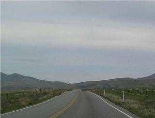 View of eastbound California 223 as it passes along the rolling foothills of the northern base of Bear Mountain.