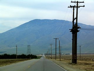 Agriculture remains the primary use of the land, even here at the southern edge of the fertile Central Valley. Like a beacon, Bear Mountain is visible in the skyline.