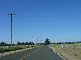 Straightening out, northbound California 229 follows ranches on both sides of Webster Road.