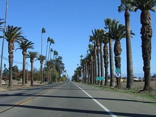 The first reassurance shield along northbound California 233 (Robertson Boulevard) appears after the exchange with California 152. A mileage sign provides the distance to the city of Chowchilla (three miles) and California 99 (Golden State Freeway) (four miles).
